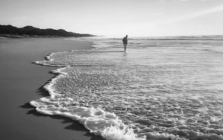 Person lost in their thoughts on a empty beach