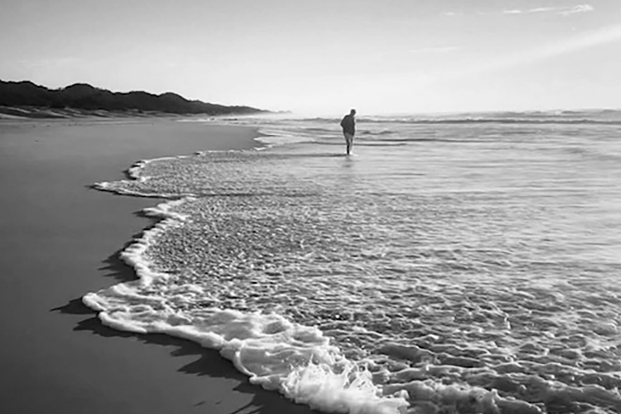 Person lost in their thoughts on a empty beach